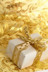 Fototapeta na wymiar Beautiful gift box on the gold background