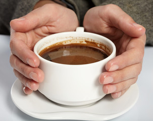 woman’s hands holding a cup of coffee