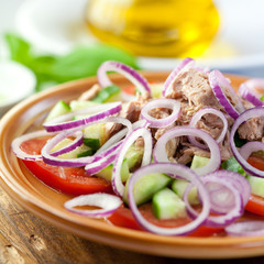 Tuna salad with vegetables on rustic kitchen board