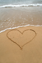 Fototapeta na wymiar heart in sand of the beach