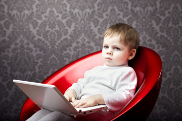 Boy sitting in a chair with a laptop