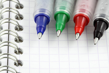 stylo gel couleurs à bille sur page de carnet à spirale