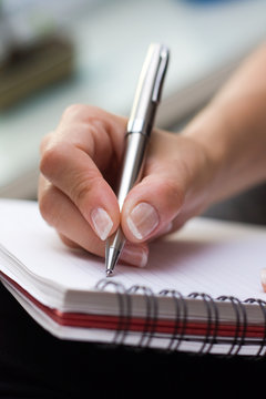 Woman writes on a paper