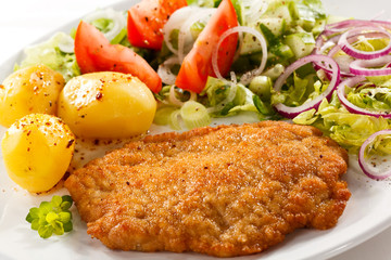 Fried pork chop with potatoes and vegetable salad