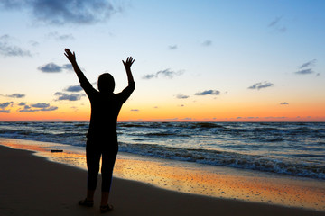 Woman doing yoga at sunset