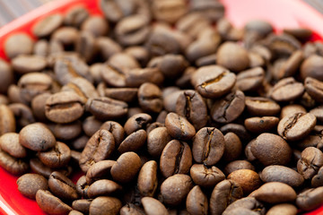 cup and saucer and coffee beans on a bamboo mat