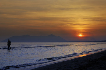 tramonto sul mare con siluette di persona