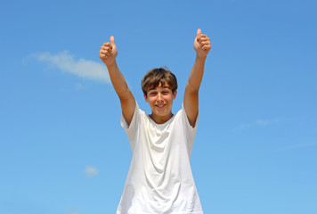 happy teenager with thumbs up on the blue sky background