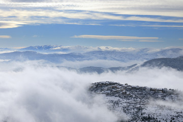 paesaggio di montagna innevato tra le nuvole