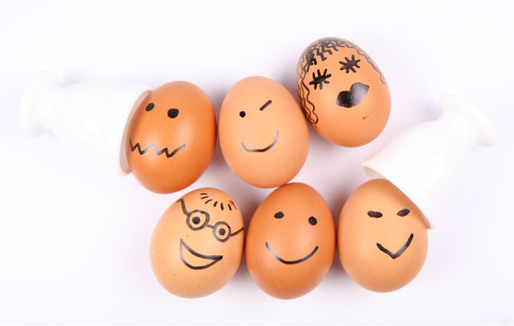 Eggs with smiling faces on white background