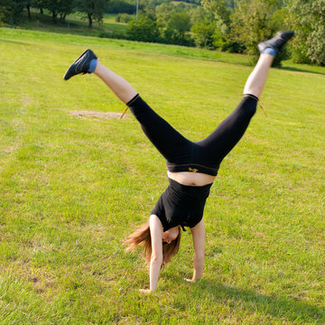 Young girl make handstand