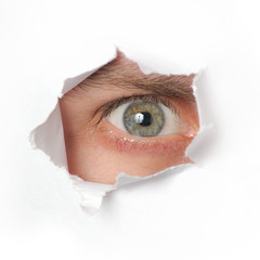 Naklejka premium Eye looking through a hole in paper