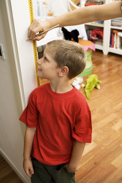 Young boy getting height measurement in doorway