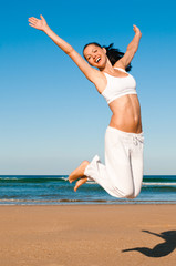 Frau springt am Strand