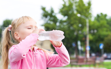The small girl is drincking water