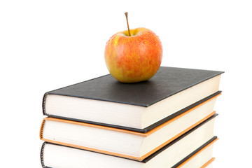 stack of books with apple over white background