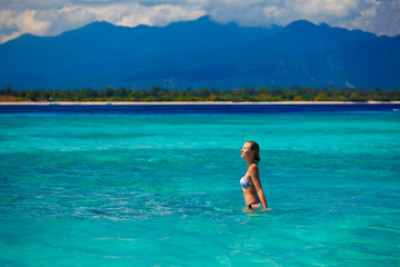 A beautiful woman wearing  white bikini on a vacant beach