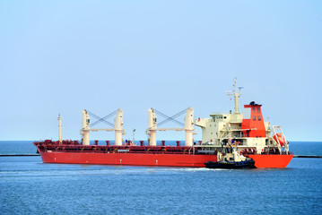 Fototapeta premium Tug boat helps to maneuver the ship