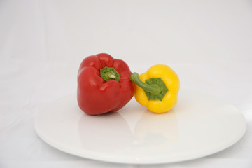 Two peppers on white plate.