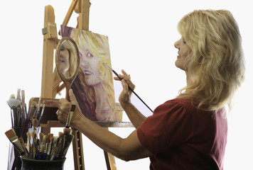 blond female artist in her fifties painting self portrait