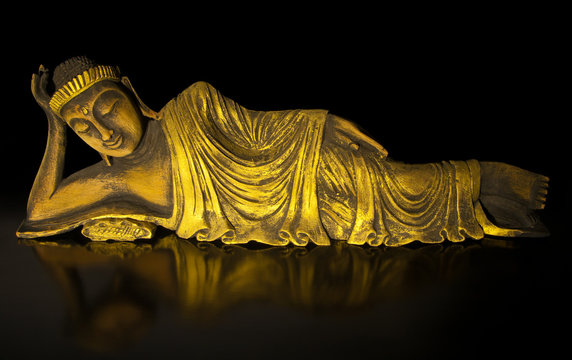 Teak wood lying buddha on black