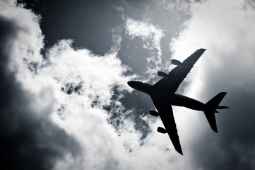 large passenger jet silhouette against clouds