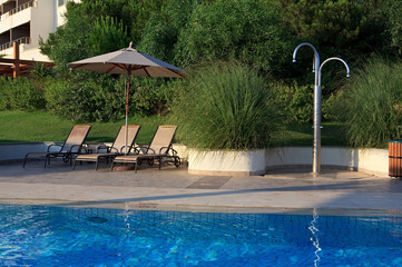 Sunbeds, umbrellas and shower near the pool.