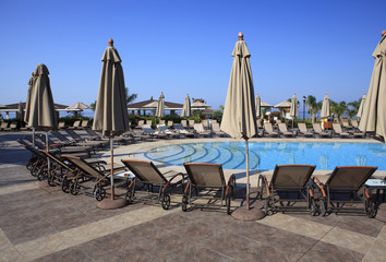 Chaise longue and umbrellas near the pool.