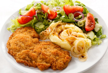 Fried pork chop with potatoes and vegetable salad