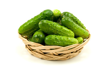 wicker dish with cucumbers. isolated on white background