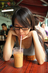 Obraz premium girl drinking a Hong Kong-style milk tea in Dai pai dong