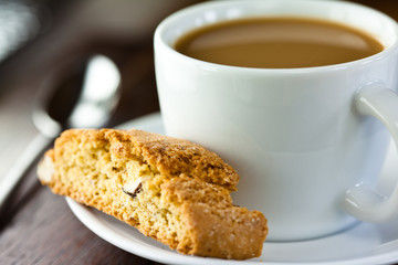 Closeup of cantuccini and a cup of coffee with milk