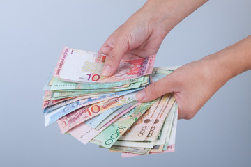 Веер из денежных купюр разных стран в женских руках