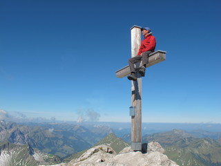 Bergsteiger am Gipfel mit Akrobatik auf Kreuz