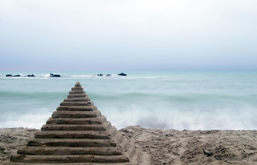 Fototapeta na wymiar Long exposure beach with pyramid in front
