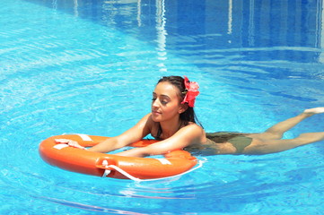 Beautiful woman tanning in a swimming pool