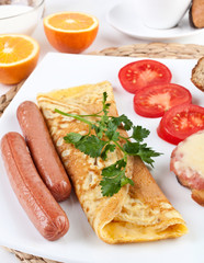 omelette with hot dogs and vegetables close up