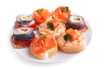 plate with salmon and herring sandwiches