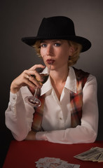 Beautiful woman in a black hat with a wine glass