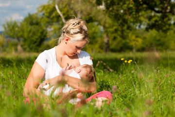 Mutter stillt Baby auf Wiese