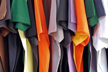 Row of colorful cotton t-shirts. Clothes background.