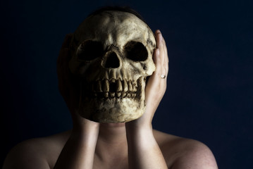 Person Holding Skull in Front of Face