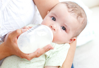 Charming mother feeding her adorable son in the kitchen