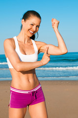 Frau zeigt auf Bizep