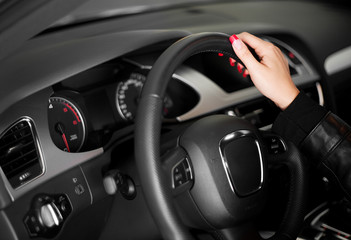 Fototapeta na wymiar Kobiety ręka na kierownicy nowoczesnego samochodu