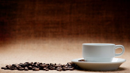 White cup c grains of coffee on grunge a background