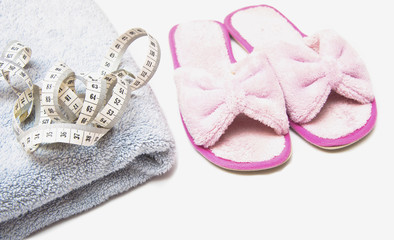 slippers, grey folded towel and metr