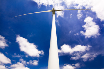 Windmill against a blue sky and clouds, alternative energy sourc