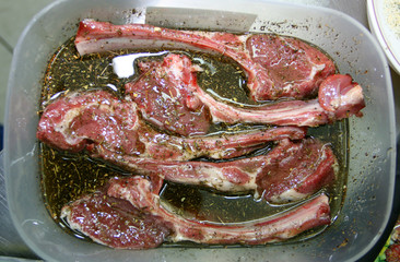 Fresh mutton on edges in marinade with spices in a tray