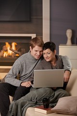 Couple using laptop at winter
